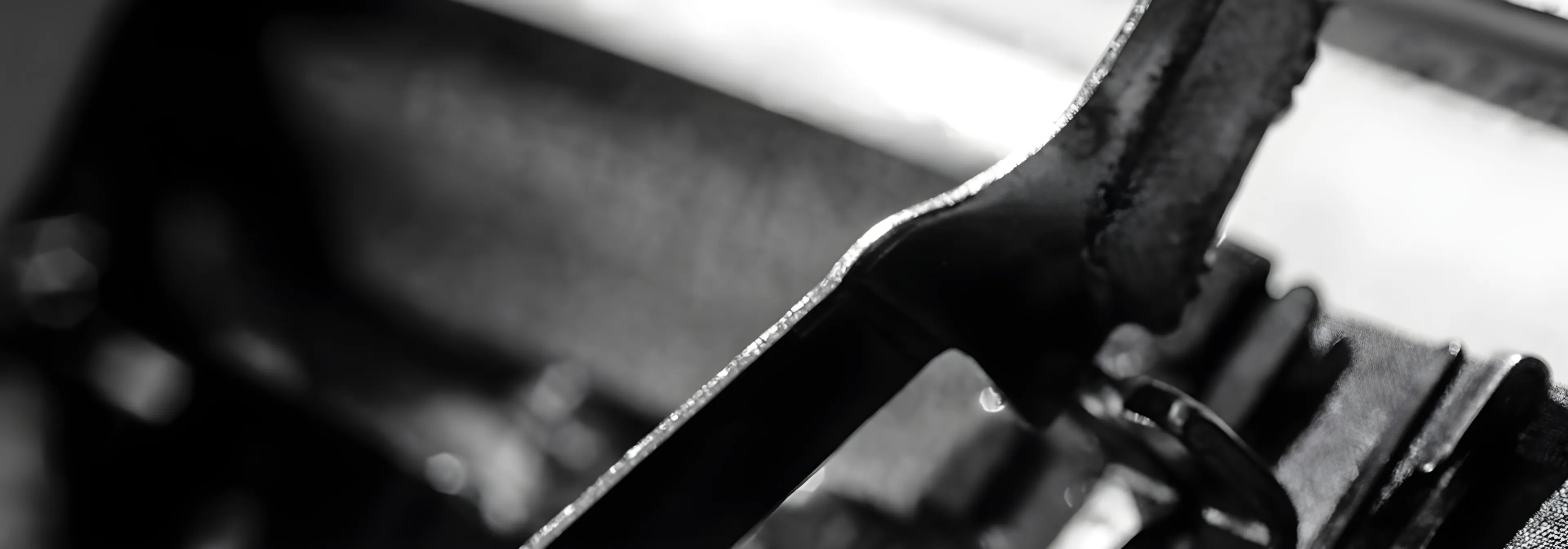 Schwarz-weiße Nahaufnahme eines mechanischen Druck- bzw. Schreibmaschinen-Bauteils, symbolisch für Handwerk und Präzision im Verlagswesen